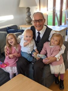 Simon chat with his 3 young grandchildren smiling at the camera